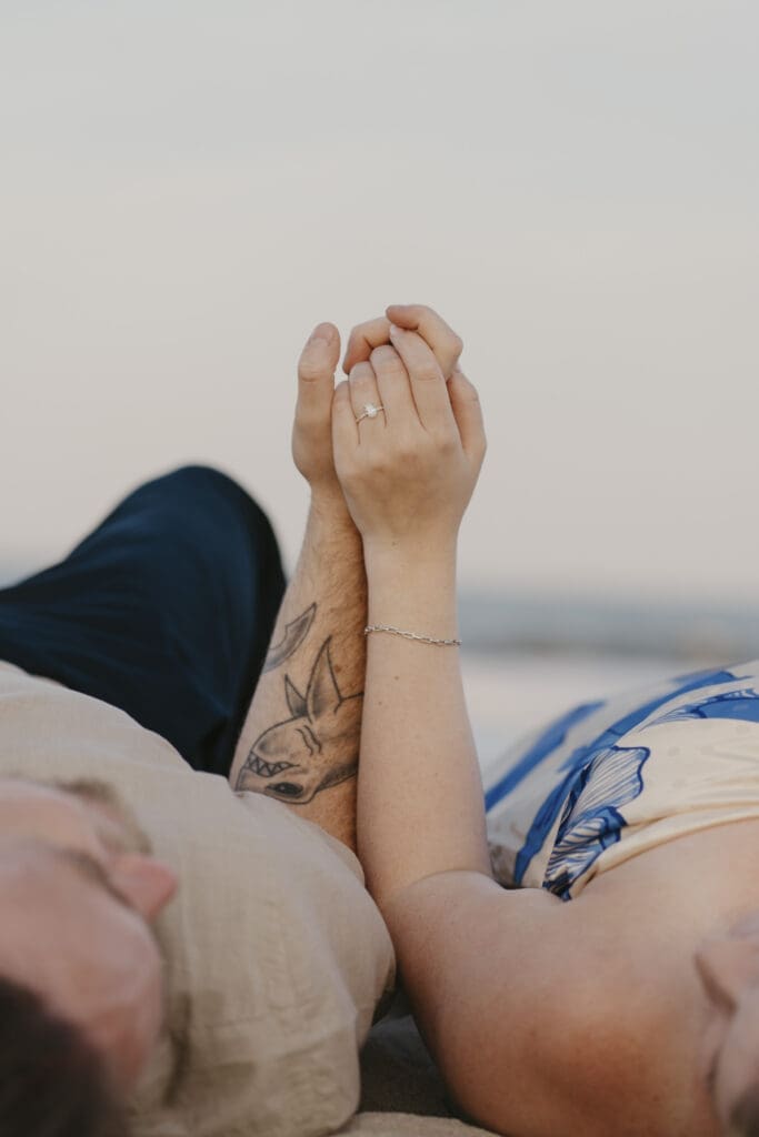 Closeup of engaged couples' hands at their beach photo shoot in Delaware