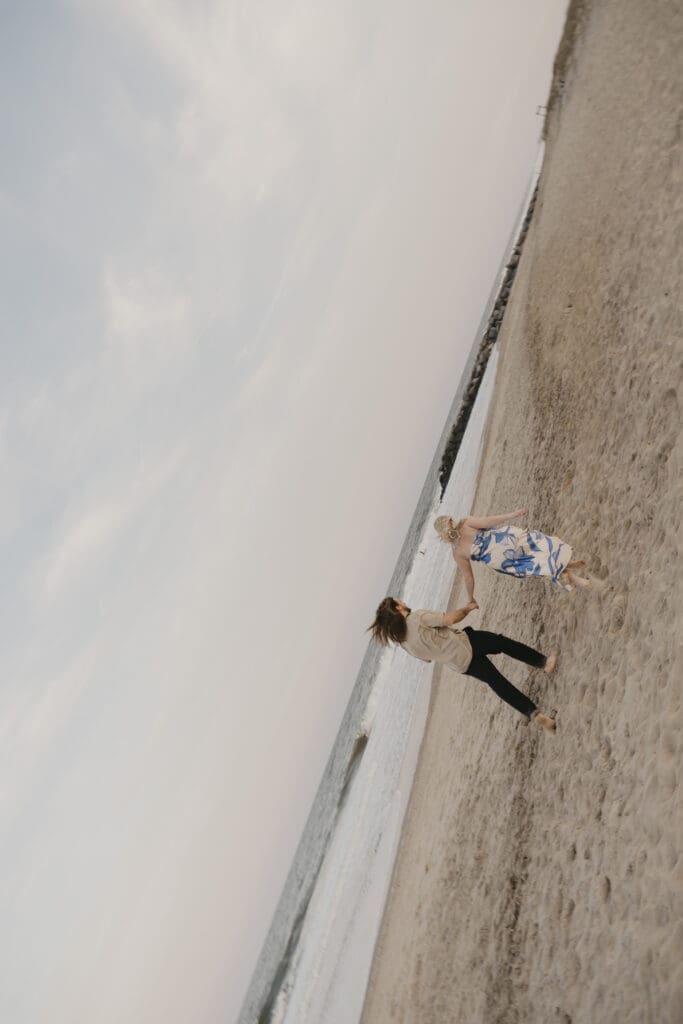 Whimsical photo at beach engagement photo shoot
